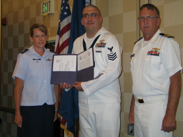 Lt. Cmdr. Doug Vanderlip, USN (l), chapter executive vice president, and Lt. Col. Jenniffer Romero, USAF, chapter Awards Committee, present the July Military Cyber Professional of the Month Award to Petty Officer 1st Class Robert Jenkins, USN, Expeditionary Strike Group Two.